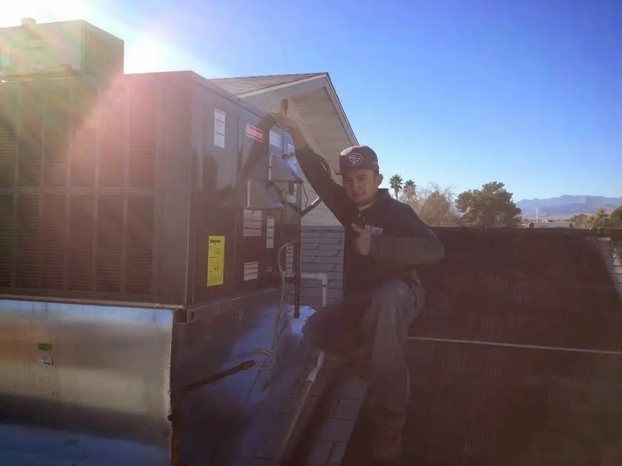 HVAC technician performing Boiler Repair on a rooftop unit in Lexington